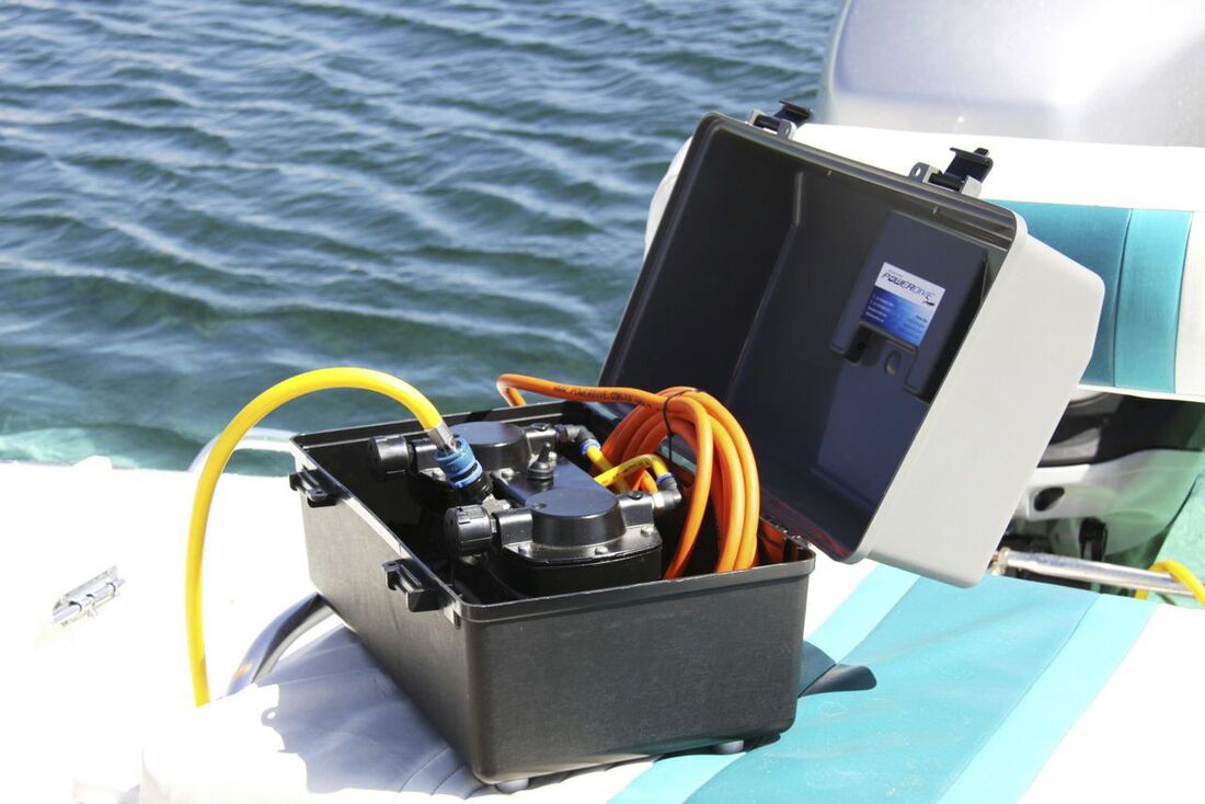 A Powerdive Decksnorkel hookah diving system sitting on the stern of a boat ready to connect to 12 volt boat battery for hookah diving